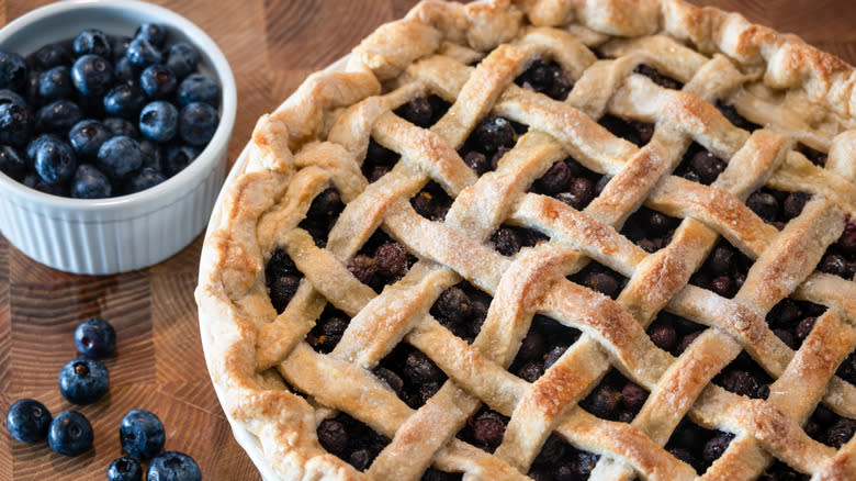 Blueberry pie with bowl of blueberries