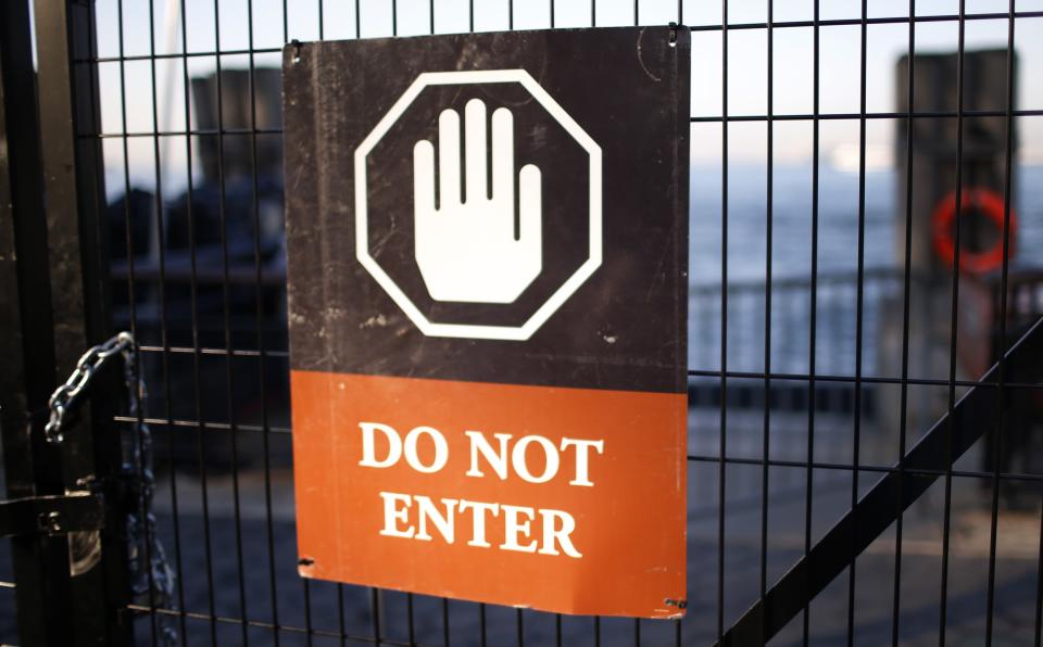 A sign hangs on a fence at the ticket entrance to the Statue of Liberty, a U.S. National Park, due to the U.S. Government shutdown at the ferry dock to the Statue of Liberty in Battery Park in New York, October 1, 2013. The U.S. government began a partial shutdown on Tuesday for the first time in 17 years, potentially putting up to 1 million workers on unpaid leave, closing national parks and stalling medical research projects. REUTERS/Mike Segar (UNITED STATES - Tags: POLITICS BUSINESS)