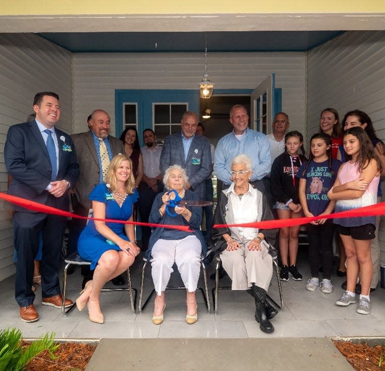 Janet Cohen, seated in middle, helps to cut the ribbon to an Avow project she helped fund for children called Aunt Janet's House, to help grieving children.