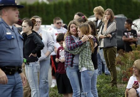 Two girls hug at Shoultes Gospel Hall church where families are reuniting after an active shooter situation at Marysville-Pilchuck High School in Marysville, Washington October 24, 2014. REUTERS/Jason Redmond