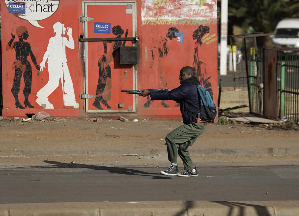 Metro police take aim on people who took part in a protest, at a shopping centre in Soweto, near Johannesburg Tuesday July 13, 2021. South Africa's rioting continued Tuesday with the death toll rising to 32 as police and the military struggle to quell the violence in Gauteng and KwaZulu-Natal provinces. The violence started in various parts of KwaZulu-Natal last week when Zuma began serving a 15-month sentence for contempt of court. (AP Photo/Themba Hadebe)