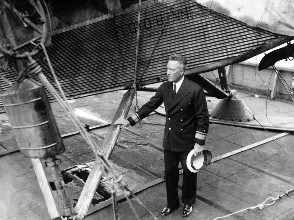 Richard Byrd posing next to the plane he used on his expedition to the South Pole.