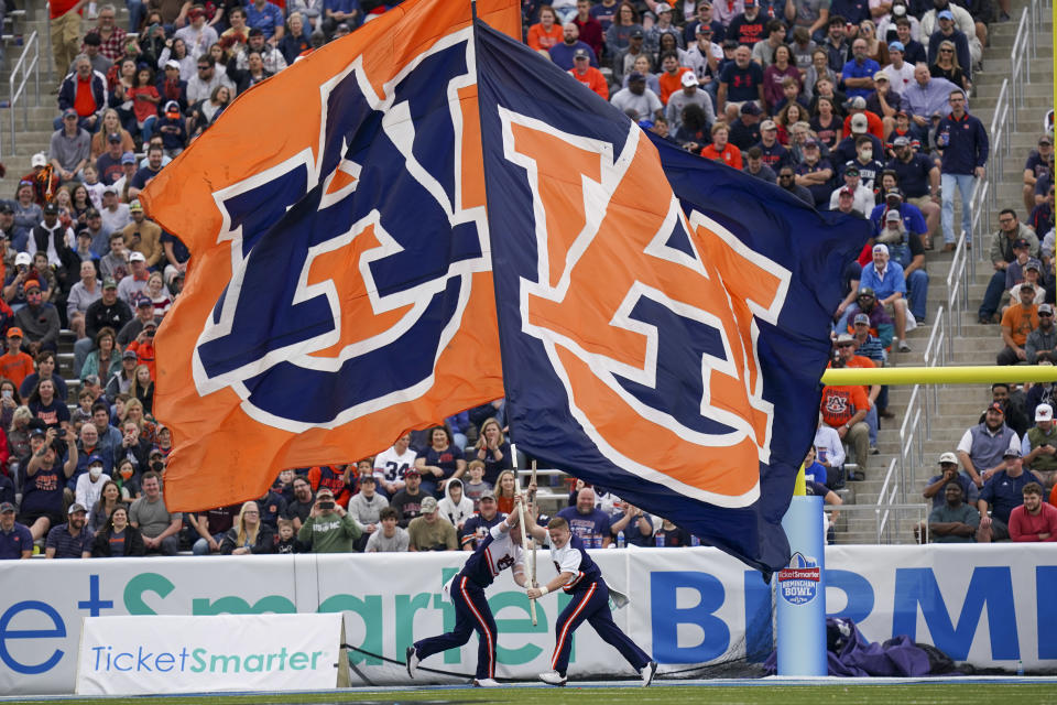 Dec. 28, 2021; Birmingham, Alabama; Auburn Tigers cheerleaders let the flags wave after a score against Houston Cougars during the second half of the 2021 Birmingham Bowl at Protective Stadium. Marvin Gentry-USA TODAY Sports