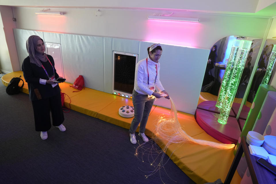 Raana Smith, left and Alison Saraf co-founders of Sensory Souk, carry out a demonstration of a sensory room at the Lusail Stadium in Lusail, Qatar, Saturday, Dec. 10, 2022. The "sensory rooms," set up for the first time in the World Cup at three stadiums in Qatar, provide a calm refuge for children and young adults with autism, learning difficulties or other sensory access requirements. (AP Photo/Andre Penner)