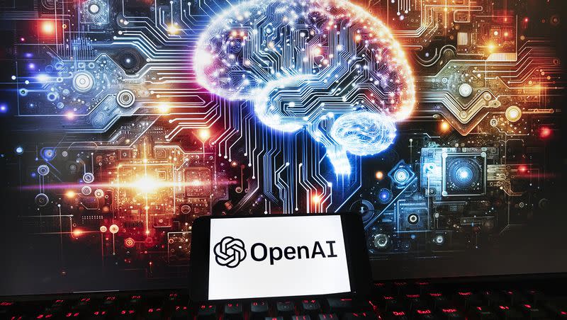 The OpenAI logo is displayed on a cellphone with an image on a computer monitor generated by ChatGPT’s Dall-E text-to-image model, Friday, Dec. 8, 2023, in Boston.