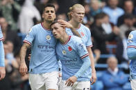 Manchester City's Phil Foden, right, celebrates with his teammate Joao Cancelo after scoring his side's first goal during the English Premier League soccer match between Manchester City and Brentford, at the Etihad stadium in Manchester, England, Saturday, Nov.12, 2022. (AP Photo/Dave Thompson)