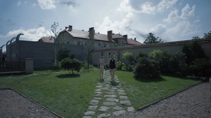 Two girls walk on a lawn in The Zone of Interest.