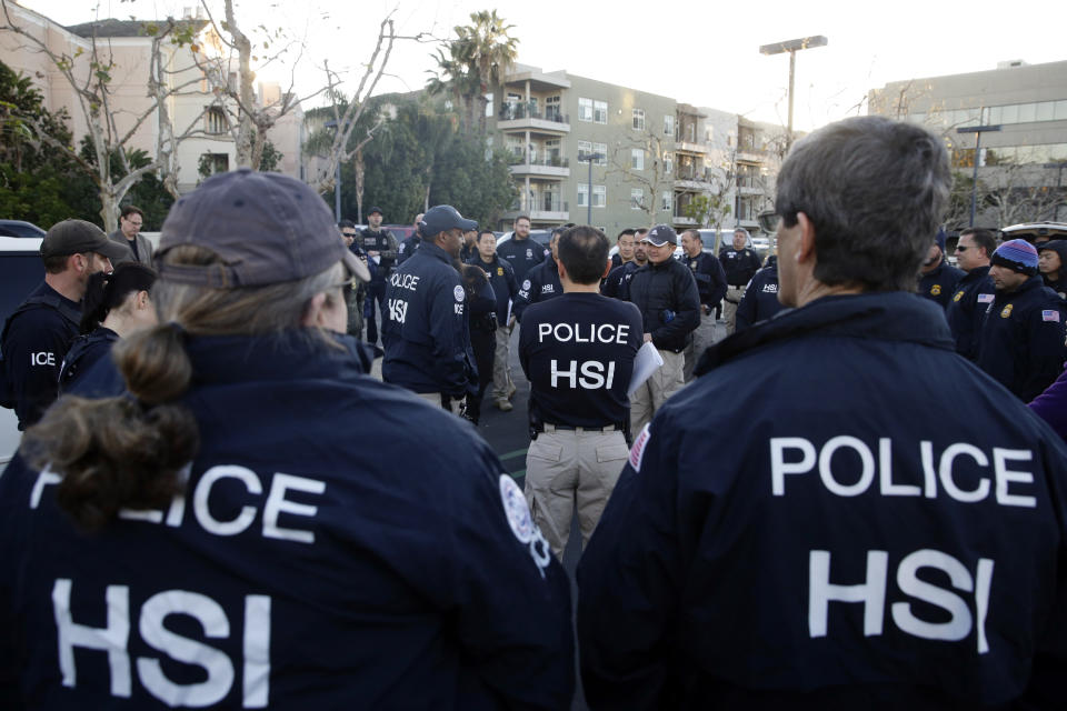 FILE - In this March 3, 2015 file photo, federal agents gather at a nearby parking lot before raiding an upscale apartment complex where authorities say a birth tourism business charged pregnant women $50,000 for lodging, food and transportation, in Irvine, Calif. On Thursday, Jan. 31, 2019, authorities announced they have charged 20 people in an unprecedented crackdown on businesses that helped hundreds of Chinese women travel to the United States to give birth to American citizen children. (AP Photo/Jae C. Hong, File)