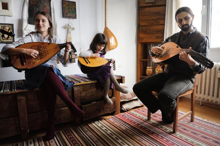 Beatrice Iordan (L), Florin Iordan (R), ethnomusicologist at the Museum of the Romanian Peasant in Bucharest plays the cobza together with their daughter, Bucharest, February 20, 2014