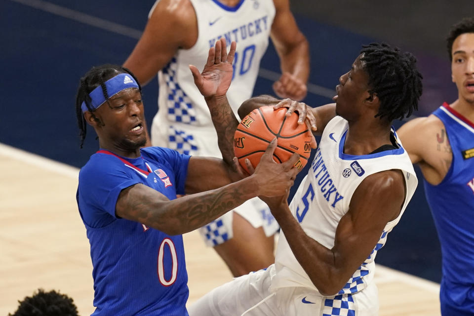 Kentucky's Terrence Clarke (5) is defended by Kansas' Marcus Garrett (0) during the first half of an NCAA college basketball game Tuesday, Dec. 1, 2020, in Indianapolis. (AP Photo/Darron Cummings)