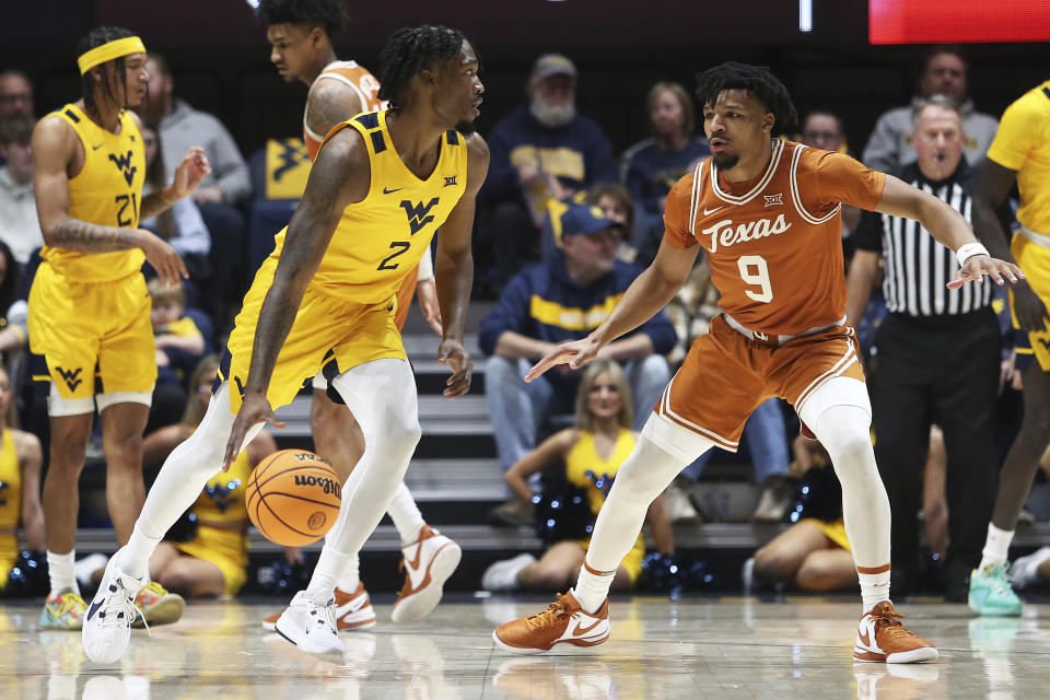 West Virginia guard Kobe Johnson (2) is defended by Texas guard Ithiel Horton (9) during the first half of an NCAA college basketball game on Saturday, Jan. 13, 2024, in Morgantown, W.Va. (AP Photo/Kathleen Batten)