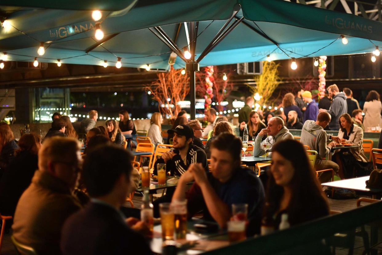 People gather at Las Iguanas restaurant and bar on Southbank in London: PA