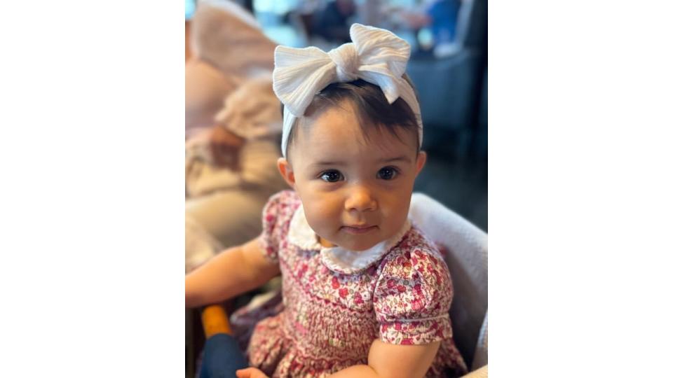 little girl wearing summer dress and white bow in hair