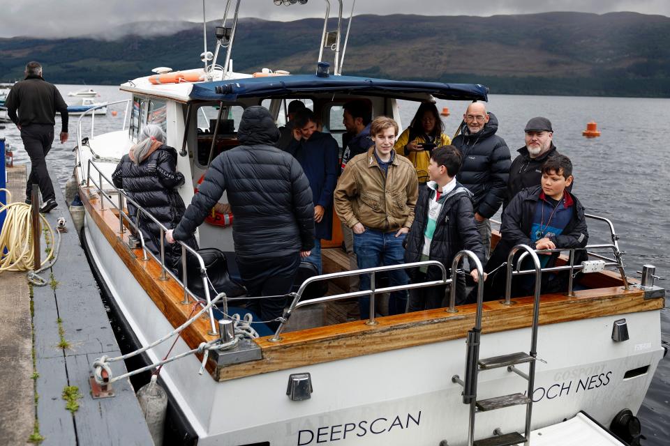 Organizer Alan McKenna, (2nd R) joins Nessie hunters on a boat on Loch Ness over the weekend of Aug. 27, 2023.