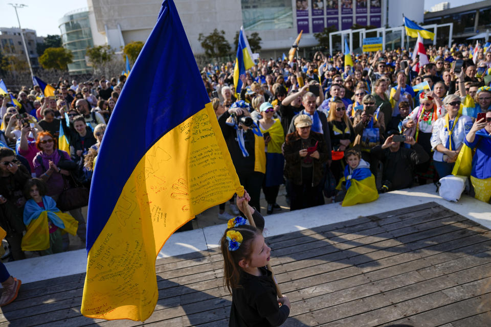 A girls holds the Ukraine flag as Ukrainians and their supporters gather to mark the one-year anniversary of Russia's invasion of Ukraine in Tel Aviv, Israel, Friday, Feb. 24, 2023. (AP Photo/Ariel Schalit)