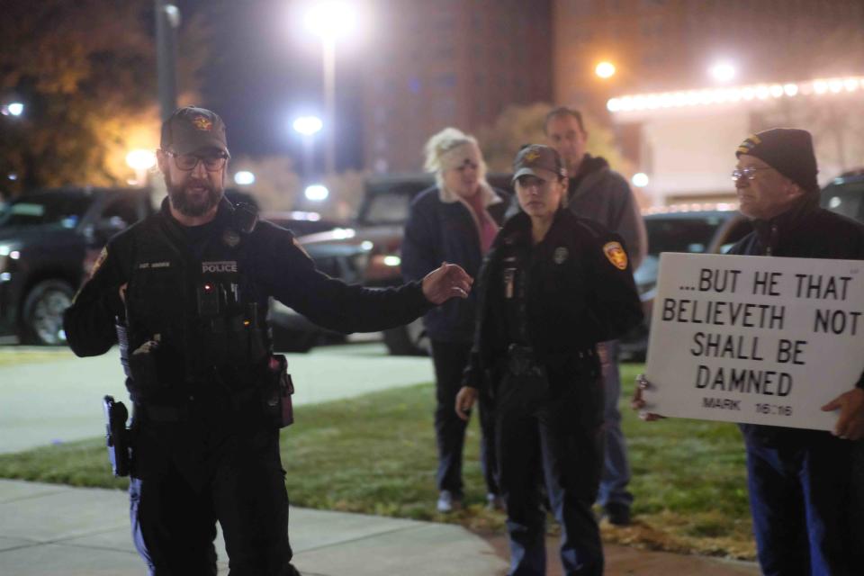 An Amarillo police officer tells protesters to move to the surrounding sidewalk during a protest Tuesday outside of the Globe-News Center for the Performing Arts in downtown Amarillo.