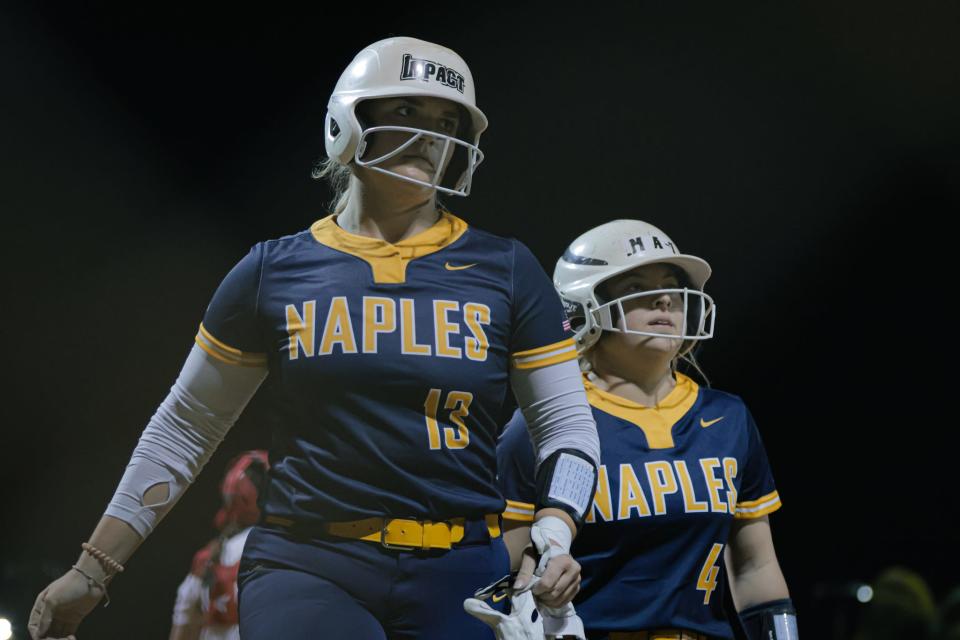 Mackenzie Leiti (13) returns to the dugout with Joslyn Baker as Naples visited Gulf Coast for a softball game on Thursday, Feb. 22, 2024. The Sharks beat the Golden Eagles 10-9.
