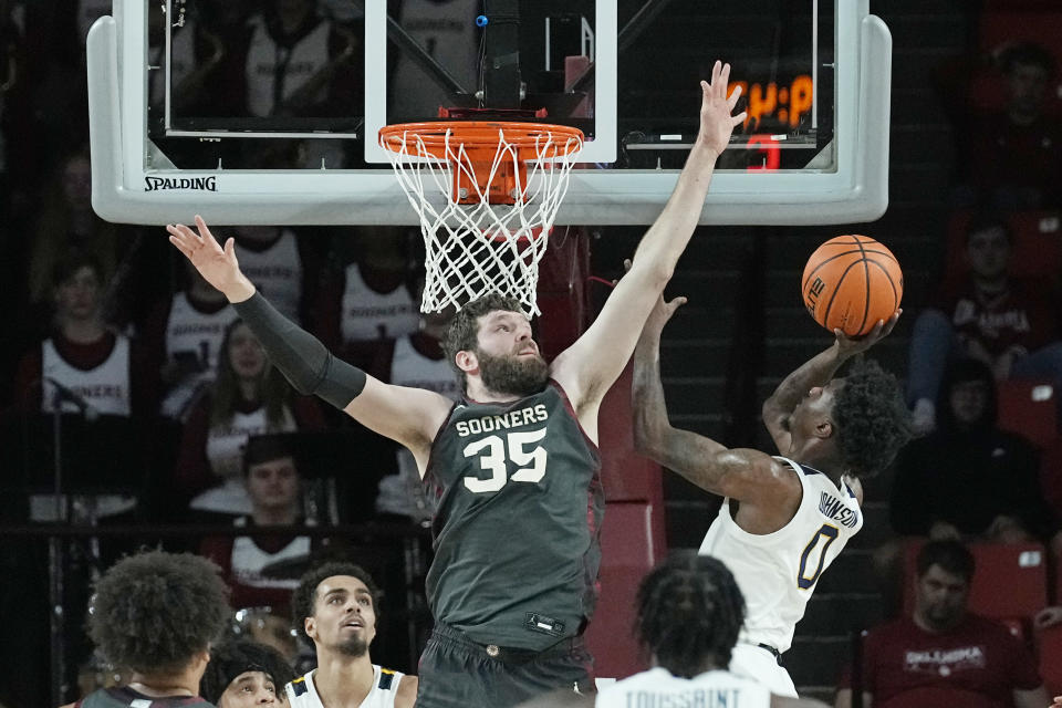 Oklahoma forward Tanner Groves (35) defends as West Virginia guard Kedrian Johnson (0) shoots in the second half of an NCAA college basketball game Saturday, Jan. 14, 2023, in Norman, Okla. (AP Photo/Sue Ogrocki)