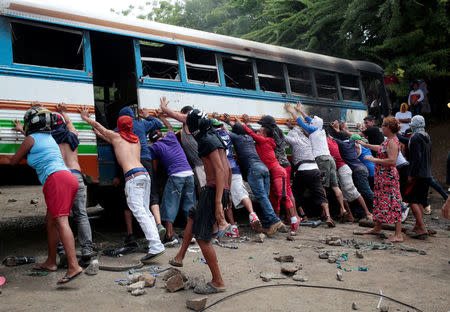 Demonstrations place a burned bus as a barricade during a protest against Nicaragua's President Daniel Ortega's government in Tipitapa, Nicaragua June 14, 2018. REUTERS/Oswaldo Rivas