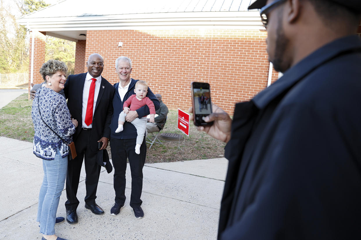 Candidate Leon Benjamin poses for a photo with Jill and Craig Seal and their grandchildren Ralph Hall, obscured, 2, and Vann Hall, 1, outside the Thomas Dale High School polling station in Richmond, Va., on Tuesday, Feb. 21, 2023. Benjamin is running to succeed Rep. Donald McEachin, D-4th. (Eva Russo/Richmond Times-Dispatch via AP)