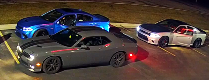 The two Dodge Chargers — one silver, the other baby blue — stolen Monday from the CR Chrysler Dodge Jeep Ram of Adrian are pictured along with a third car in a nearby parking lot.