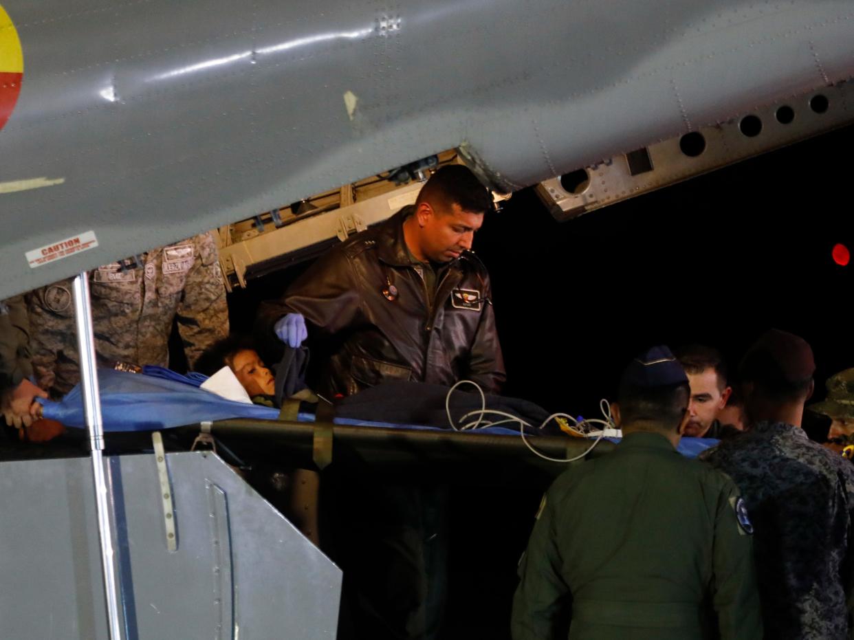 Military personnel unload from a plane one of four Indigenous children who were missing after a deadly plane crash at the military air base in Bogota, Colombia, Saturday, June 10, 2023. The children survived a small plane crash 40 days ago and had been the subject of an intense search in the jungle.