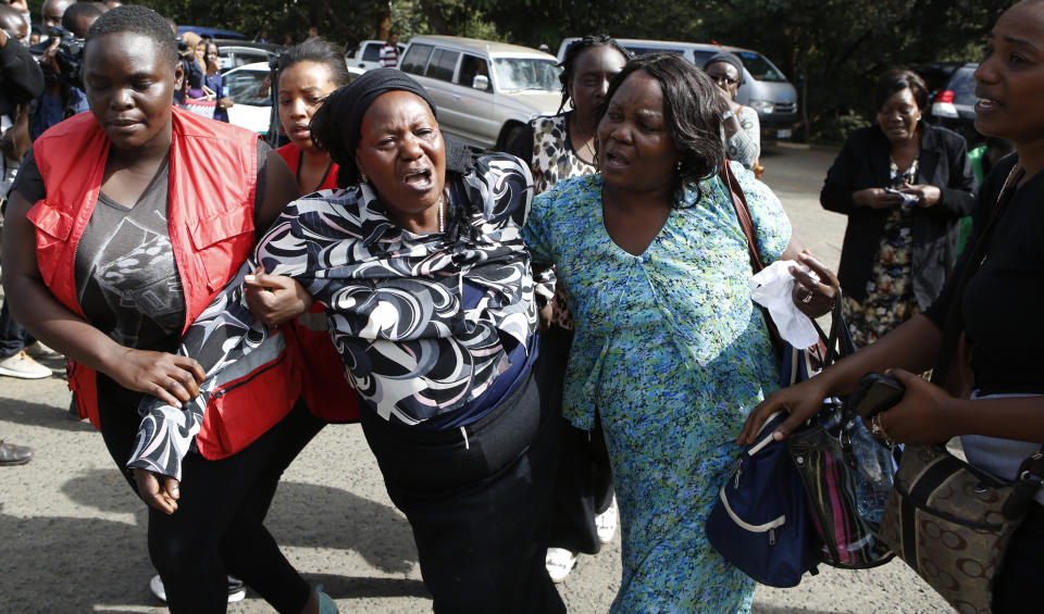 Kenya Red Cross personnel helps a woman reacting after learning of a family member killed during a recent terrorist attack Wednesday, Jan. 16 2019, at the Chiromo Mortuary, Nairobi, Kenya. An upscale hotel complex in Kenya's capital came under attack on Tuesday, with a blast and heavy gunfire. The al-Shabab extremist group based in neighboring Somalia claimed responsibility and said its members were still fighting inside (AP Photo/Brian Inganga)