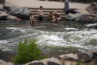 People cool off in the water at the confluence of the South Platte River and Cherry Creek in Denver, on Wednesday June 16, 2021. A heat wave continues to hover over the western U.S., pushing the temperature to 99 degrees in Denver. (AP Photo/Brittany Peterson)