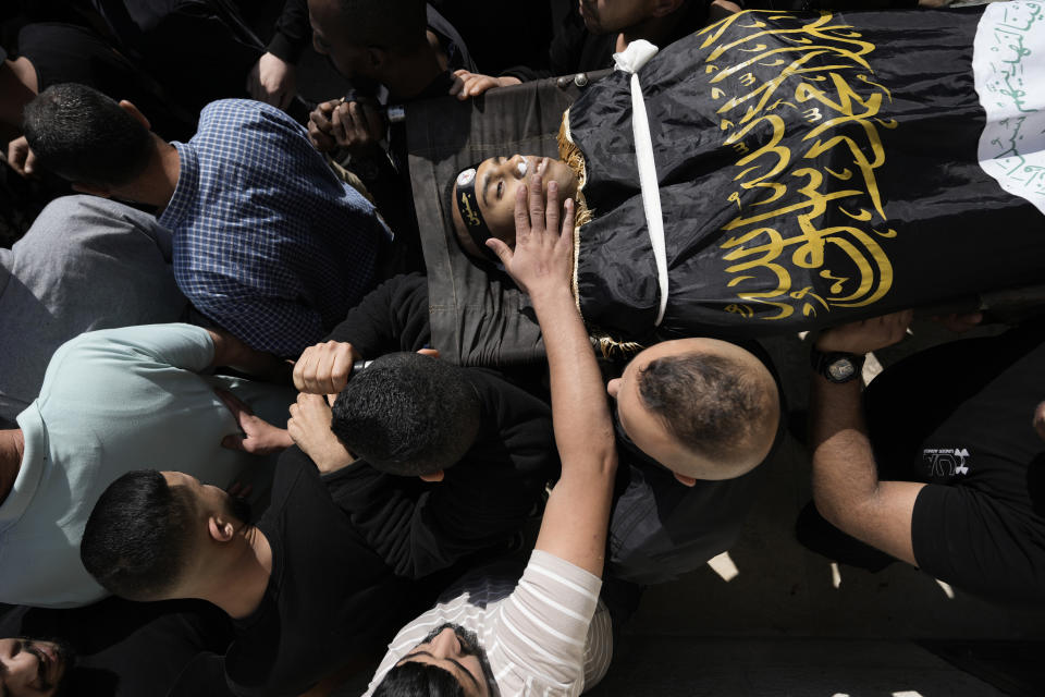 Mourners carry Rani Qatanat, 24, draped in the flag of Islamic Jihad, one of two Palestinians killed by Israeli forces in Qabatiya, near the West Bank city of Jenin, Wednesday, May 10, 2023. The Israeli military said that Palestinian gunmen opened fire at troops in the Palestinian town of Qabatiya in the northern West Bank during an army raid. Troops returned fire, killing the two men, and confiscated their firearms, it said. (AP Photo/Majdi Mohammed)