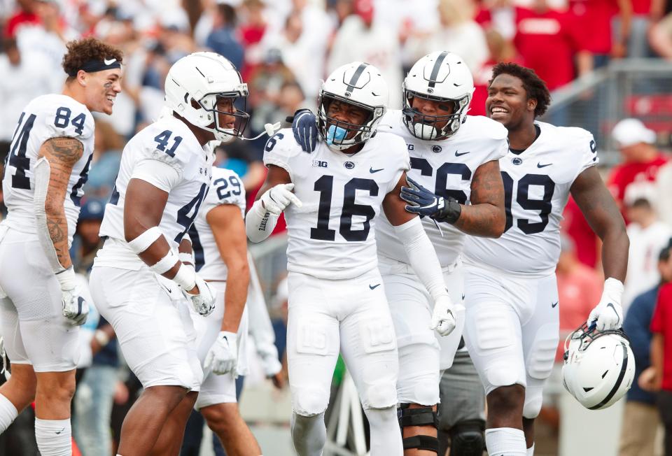 Penn State safety Ji'Ayir Brown (16) is surrounded by teammates following a win against Wisconsin to open the 2021 season. Brown, then a little-known commodity for the Nittany Lions' defense, is now considered a team leader.