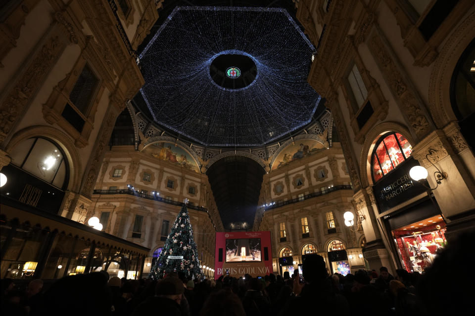 People gather inside the Vittorio Emanuele II gallery to watch the premiere of La Scala opera house on a screen in Milan, Italy, Wednesday, Dec. 7, 2022. Italy's most famous opera house, Teatro alla Scala, opens its new season 2022/2023 Wednesday with the Russian opera "Boris Godunov," against the backdrop of Russia's invasion of Ukraine and Ukrainian protests that the cultural event is a propaganda win for the Kremlin. (AP Photo/Antonio Calanni)