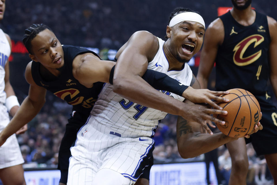 Orlando Magic center Wendell Carter Jr. (34) controls a rebound against Cleveland Cavaliers forward Isaac Okoro during the first half of Game 5 of an NBA basketball first-round playoff series, Tuesday, April 30, 2024, in Cleveland. (AP Photo/Ron Schwane)