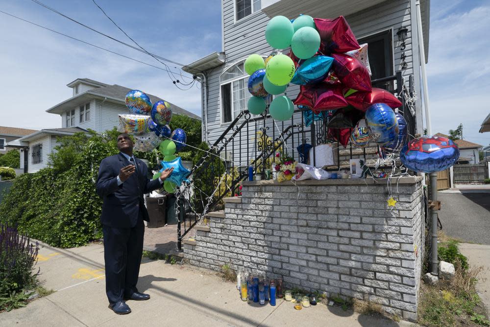 Minister Isaac Mickens says a prayer at a memorial for ten-year-old Justin Wallace, Tuesday, June 8, 2021 in the Far Rockaway neighborhood of New York. (AP Photo/Mark Lennihan)