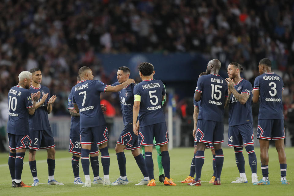 PSG's Angel Di Maria, at center embraces PSG's Kylian Mbappe as he is substituted in his final game for the club during the French League One soccer match between Paris Saint Germain and Metz at the Parc des Princes stadium in Paris, France, Saturday, May 21, 2022. (AP Photo/Michel Spingler)