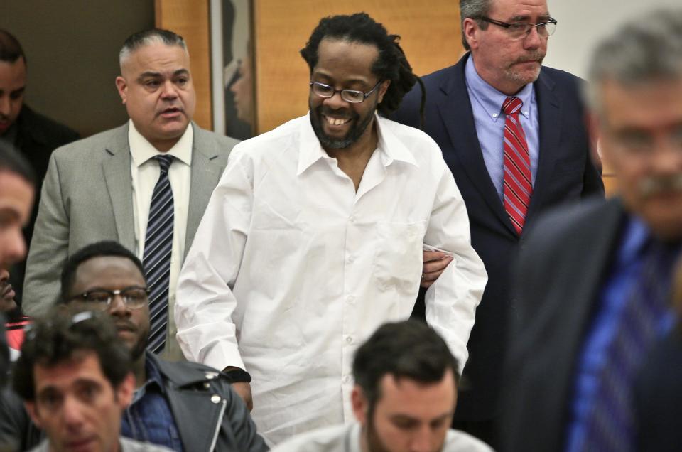 Robert Hill, center, smiles as he is escorted into Brooklyn Supreme Court, Tuesday May 6, 2014 in New York. Hill and his half brothers Alvena Jennette and Darryl Austin were exonerated in a decades-old conviction investigated by homicide detective Louis Scarcella, whose tactics have come into question. (AP Photo/Bebeto Matthews)