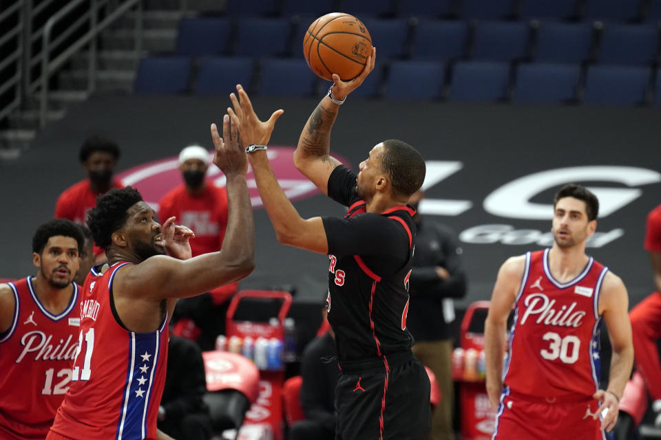 Toronto Raptors guard Norman Powell (24) shoots over Philadelphia 76ers center Joel Embiid (21) during the first half of an NBA basketball game Tuesday, Feb. 23, 2021, in Tampa, Fla. (AP Photo/Chris O'Meara)