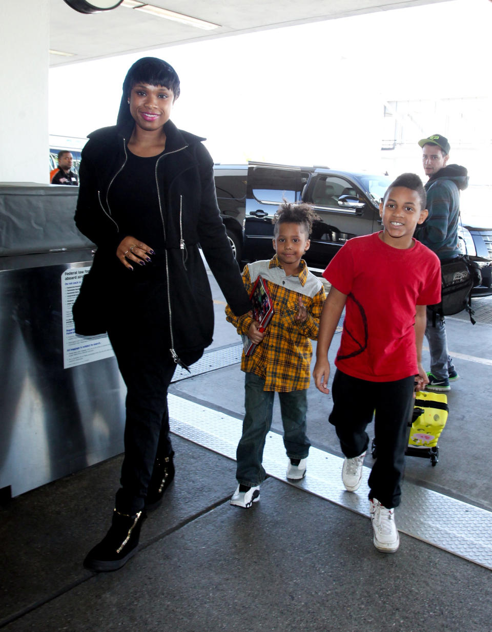 Jennifer Hudson’s kids are cuter than your carry on (especially the one in a fashionable gingham button down with a Spongebob rolling suitcase). The singer wears the celebrity airport uniform of head-to-toe black.