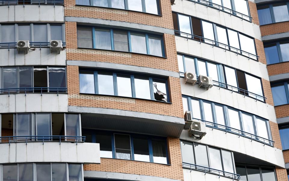 A broken window in a multi-storey apartment block following a reported drone attack in Moscow - MAXIM SHEMETOV/REUTERS