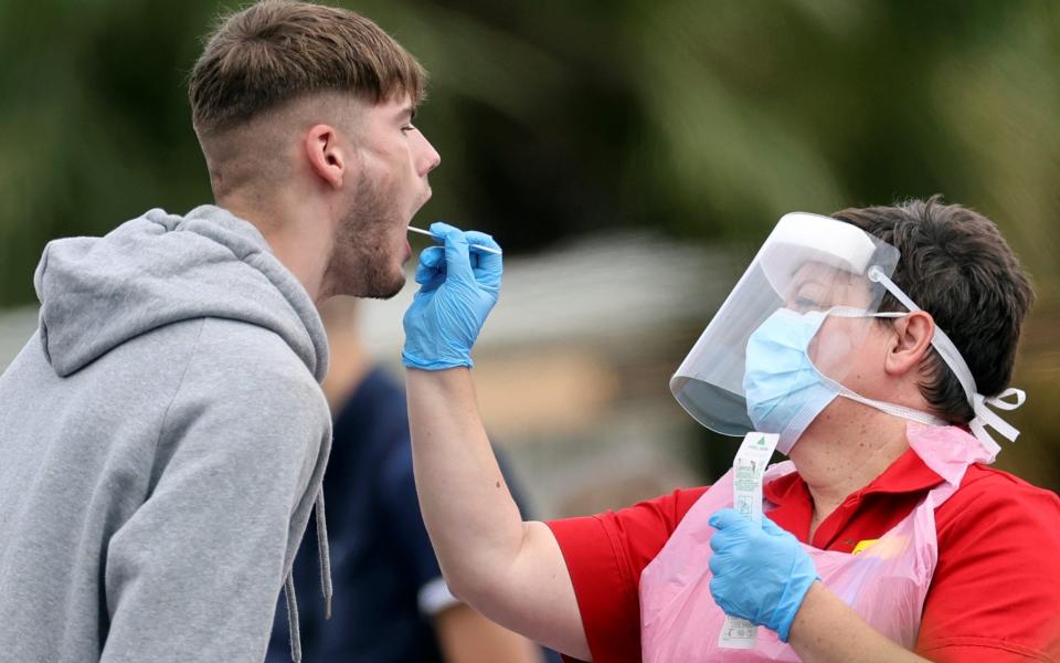 A medical worker takes a swab sample following a spike in cases of the coronavirus disease (COVID-19) to visitors of a pub in Stone, Britain, July 29, 2020. REUTERS/Carl Recine - Reuters