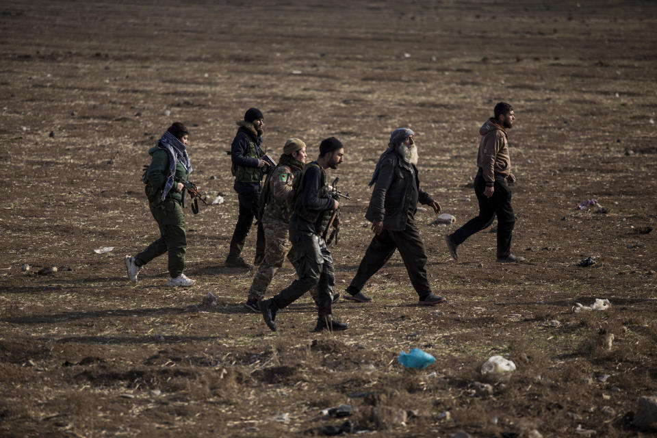 Syrian Democratic Forces fighters escort suspected Islamic State militants in Hassakeh, northeast Syria, Wednesday, Jan. 26, 2022. Dozens of armed Islamic State militants remained holed up in the last occupied section of a Syrian prison, U.S.-backed Kurdish-led forces said Thursday. The two sides clashed a day after the Syrian Democratic Forces announced they had regained full control of the facility. (AP Photo/Baderkhan Ahmad)