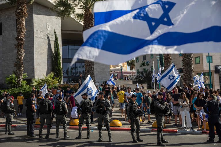 Agentes de la policía fronteriza paramilitar israelí montan guardia mientras manifestantes judíos de derecha exigen la liberación de tres judíos arrestados por asesinato frente al Tribunal de Distrito en Lod