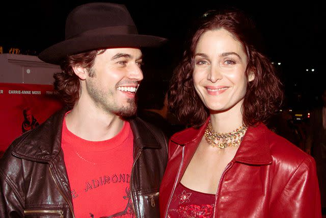 <p>Kevin Winter/Getty</p> Steven Roy and Carrie-Anne Moss in Los Angeles in November 2000.