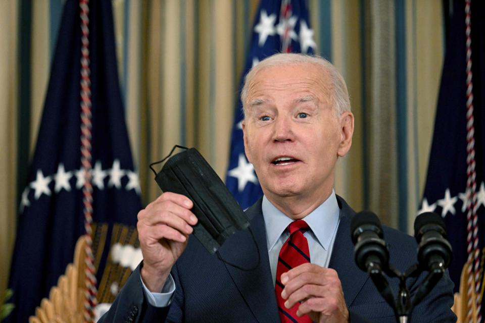 President Joe Biden holds up a face mask while speaking about strengthening US ports and supply chains after the International Longshore and Warehouse Union and the Pacific Maritime Association finalized a new contract covering west coast ports, in the State Dining Room of the White House in Washington, DC, on September 6, 2023.
