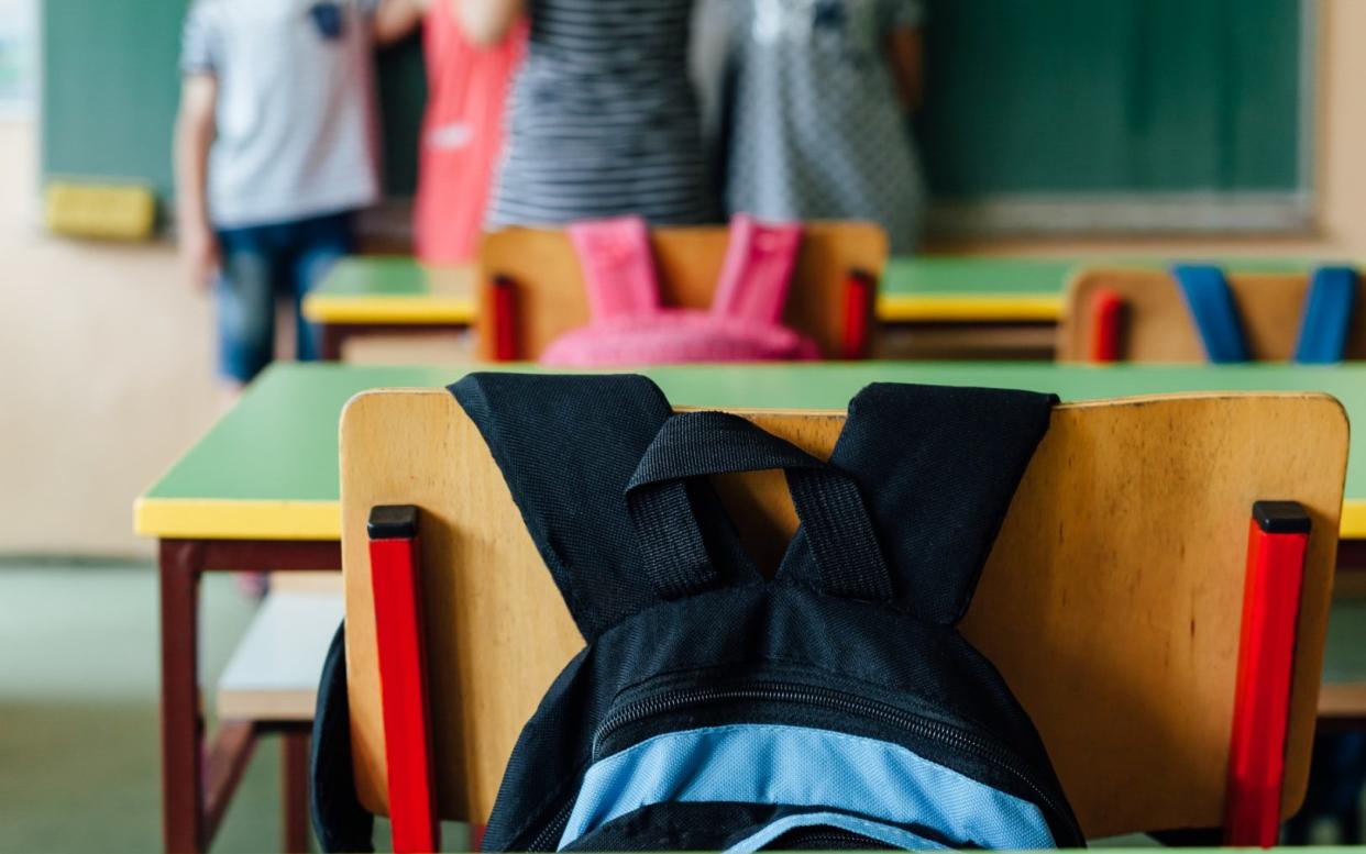 An empty classroom, with a bag and students