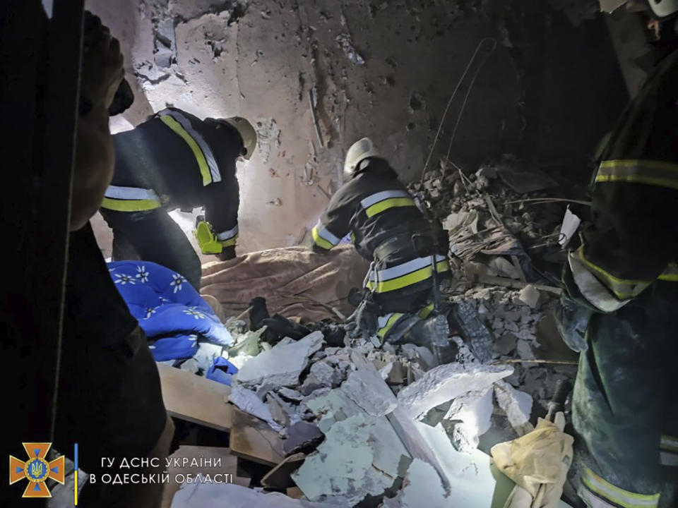 In this photo provided by the Ukrainian Emergency Service, first responders work in a damaged residential building in Odesa, Ukraine, early Friday, July 1, 2022, following Russian missile attacks. Ukrainian authorities said Russian missile attacks on residential buildings in the port city of Odesa have killed more than a dozen people. (Ukrainian Emergency Service via AP)