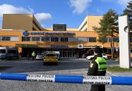 Police officers walks outside the University Hospital, which was a site of a shooting, in Ostrava