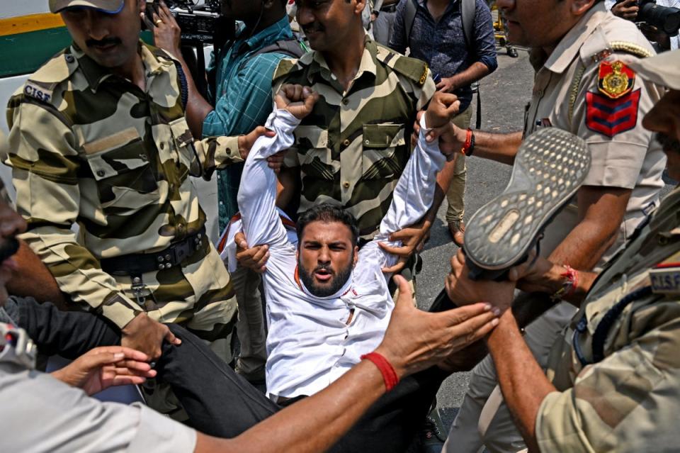 A member of the Indian Youth Congress is detained by policemen during a protest (AFP via Getty Images)