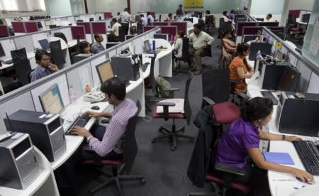 FILE PHOTO: Workers are seen at their workstations on the floor of an outsourcing centre in Bangalore, February 29, 2012. REUTERS/Vivek Prakash/File Photo