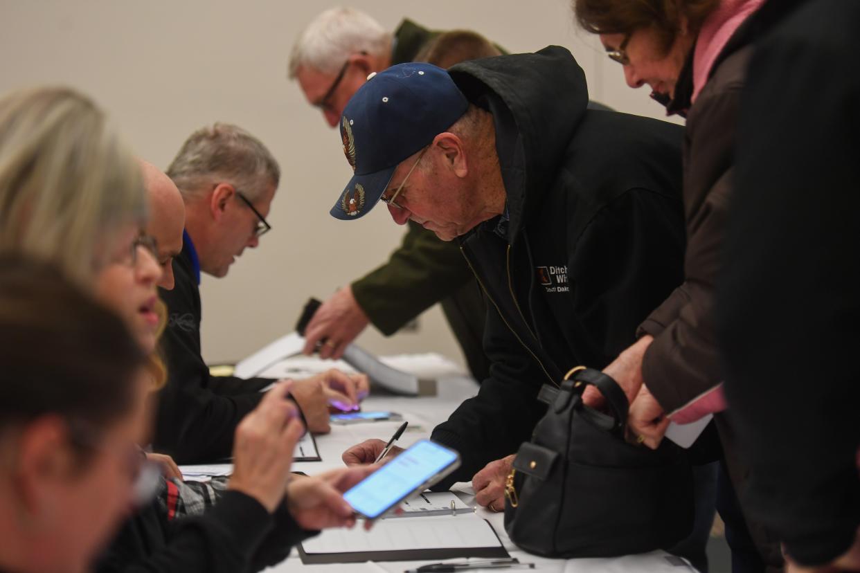 Caucus goers sign in at the front desk during the Iowa caucus on Monday, Jan. 15, 2024 at Terrance View Event Center in Sioux Center, Iowa.