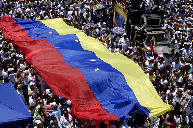 Opponents of Venezuelan President Nicolas Maduro carry a national flag during a peaceful demonstration against his government, in Caracas, on May 30, 2015